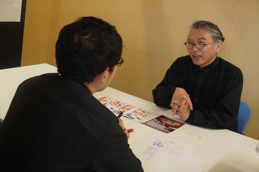 事務局の正村が取材を受ける様子